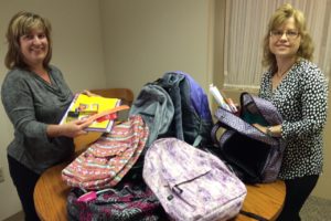 GKH paralegals Susan Miller and Jennifer Marcus with some of the 18 backpacks donated to LAPA.